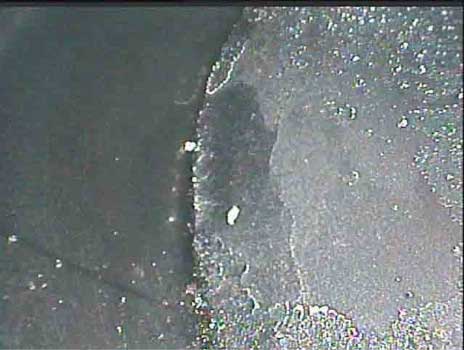 Image of FOD in the combustion chamber in the form of broken spark plug pieces taken by a VJ-Advance video borescope during an automotive engine inspection