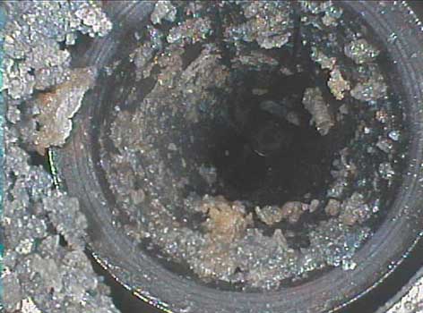 Pump drain clogged with debris seen during a corrosion inspection as shown through a VJ-Advance video borescope